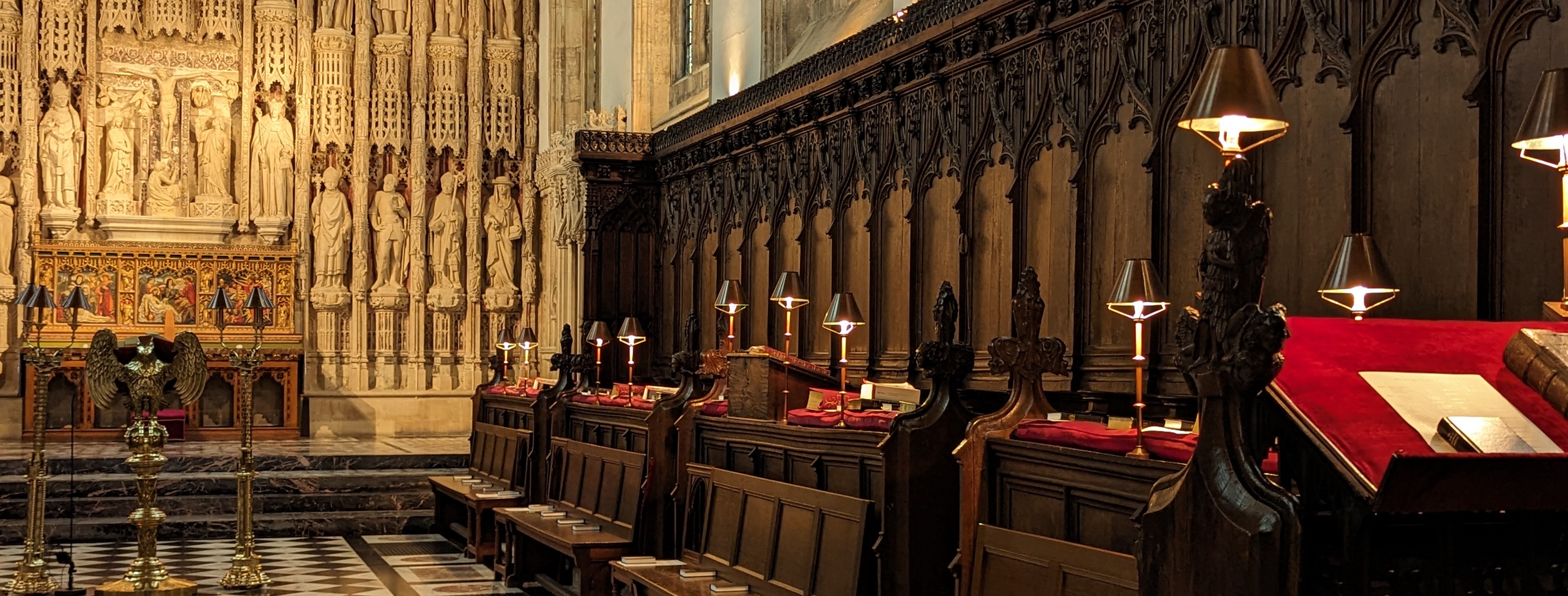 The seats in the chapels with lamps, ornate reredos in the background